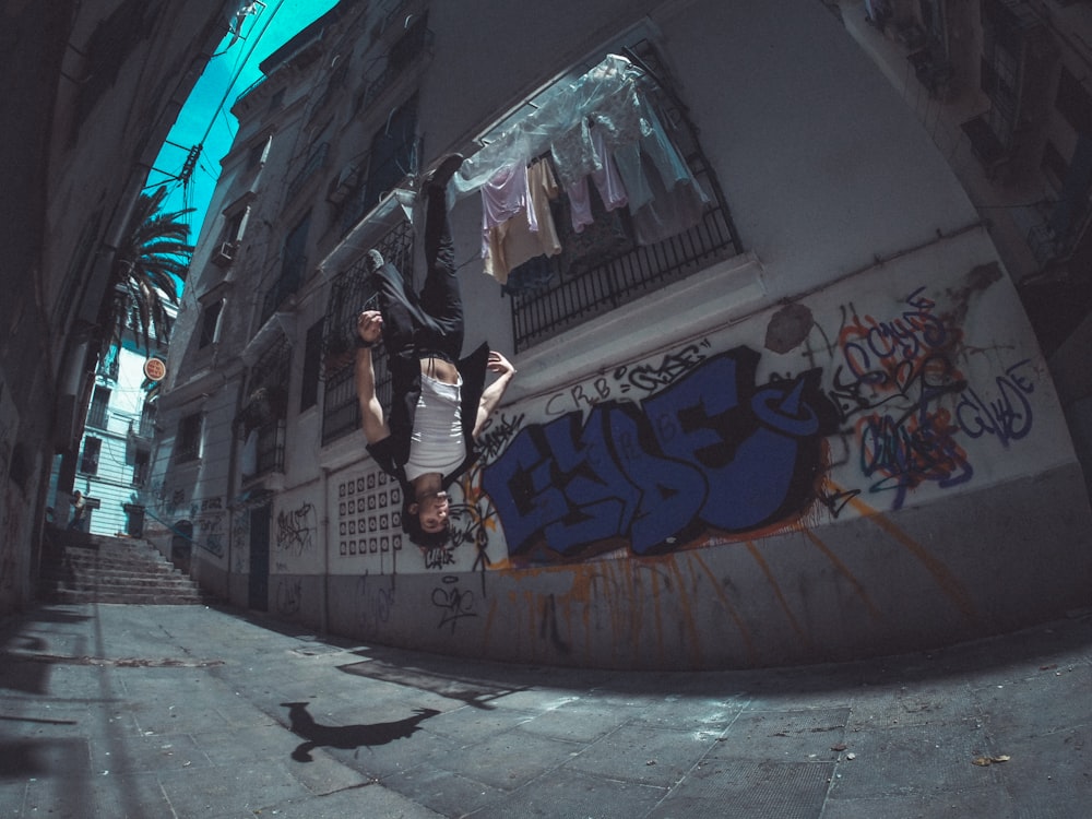 man performing backflip between house