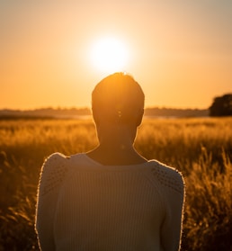 woman sitting in front of grassfield