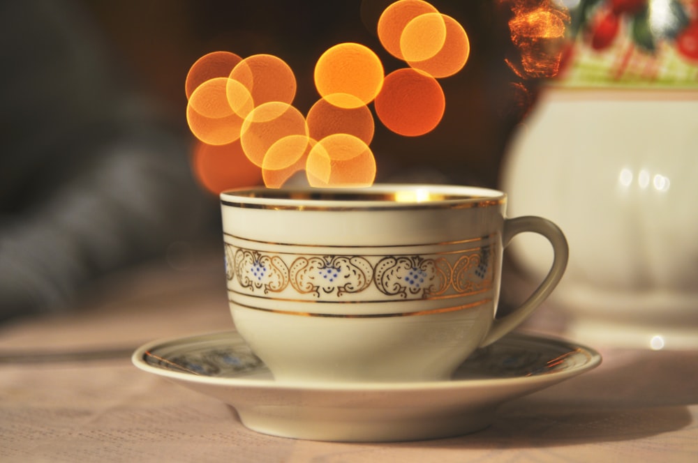 xícara de chá de cerâmica branca e marrom na mesa
