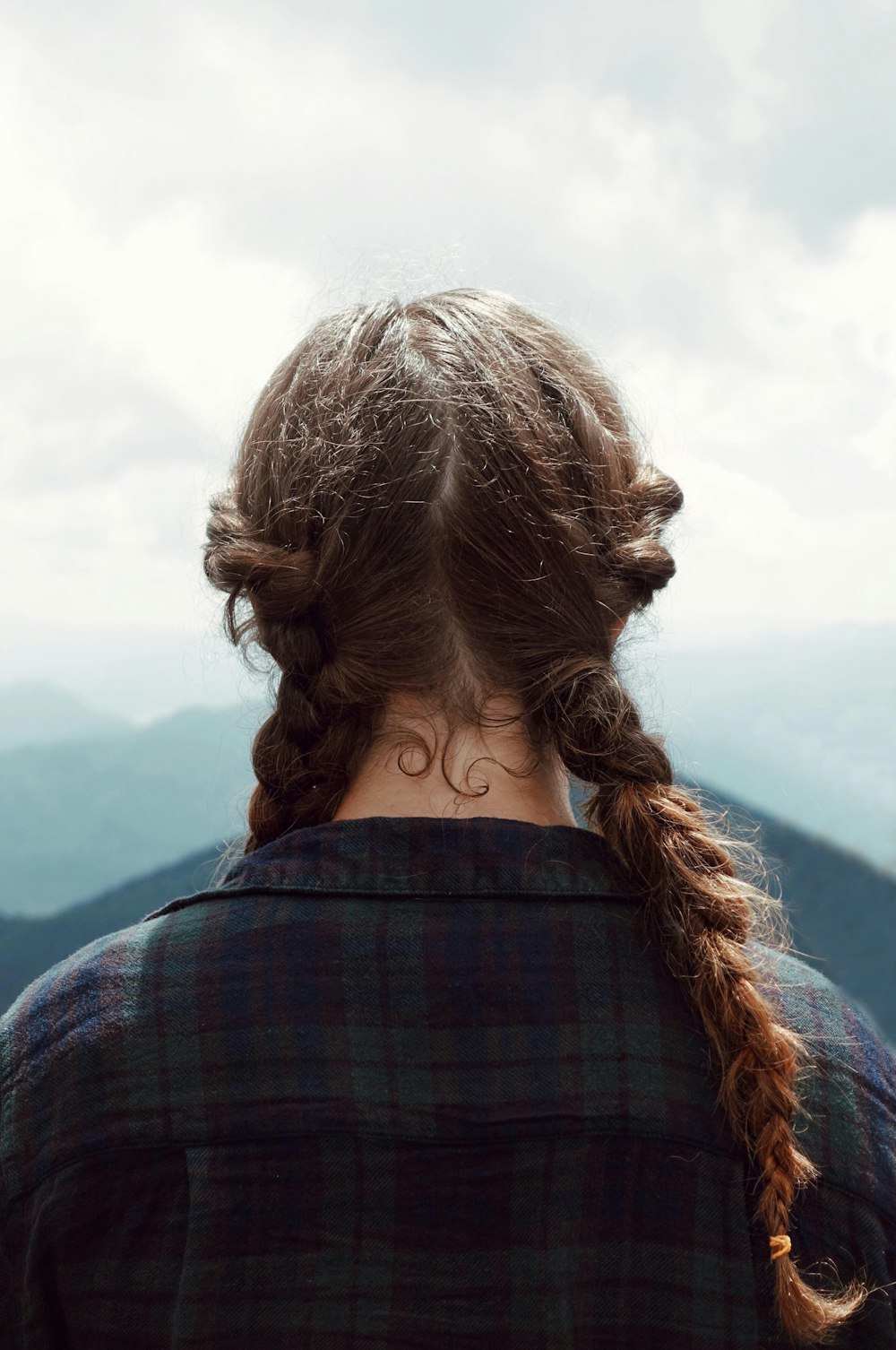 Mujer en la parte superior de cuello negro que mira en un paisaje
