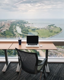 a laptop computer sitting on top of a wooden desk