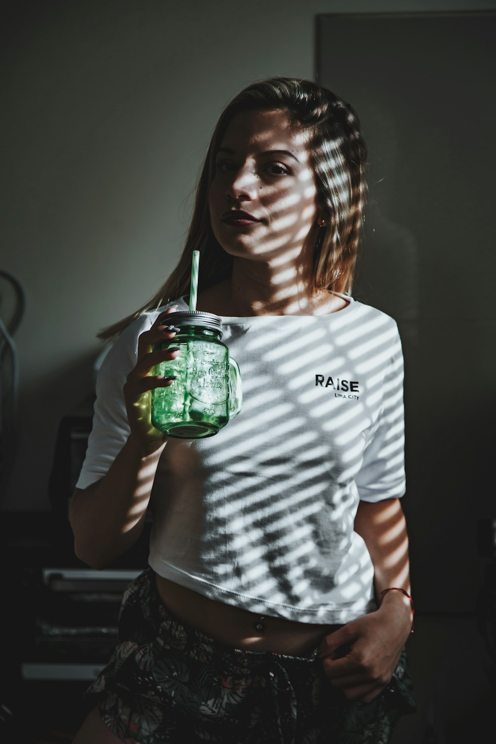 person holding green mason jar