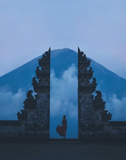 woman in between on concrete landmarks near white clouds