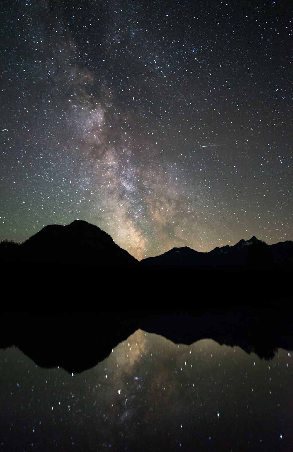 reflection photography of mountain and nebula