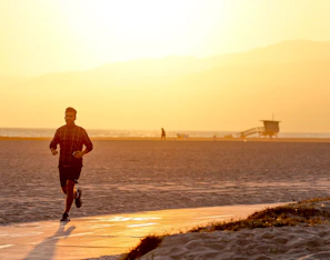 Sunset view of runners jogging along a Levante beach path, capturing the spirit of community