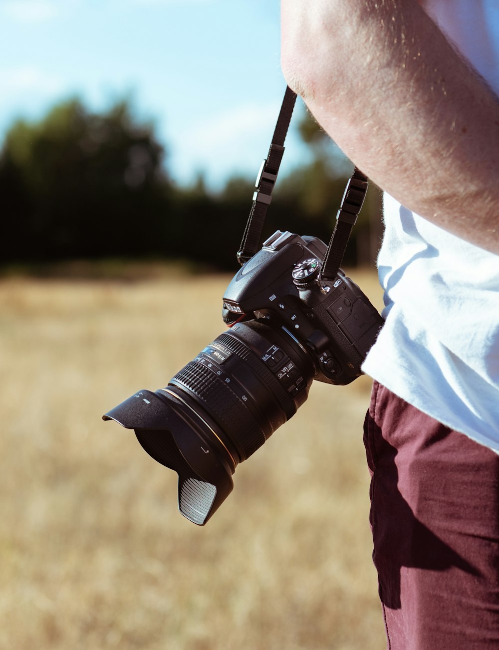 person holding camera standing on grass
