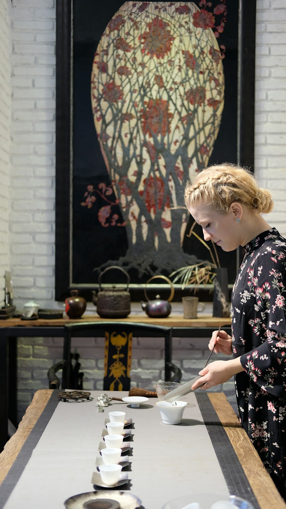 woman pouring into cup in table