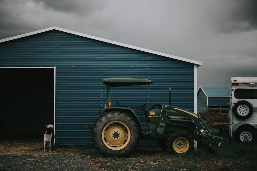 A person photographing a green tractor at close range.
