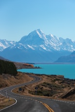 snow covered mountain near body of water during daytime