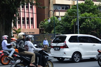A busy city street scene with multiple Big Giant Rides cars and motorcycles navigating through traffic.