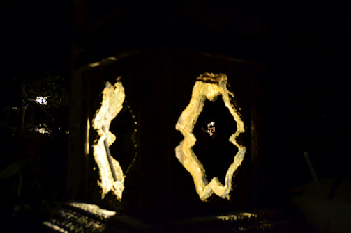 Close-up of a glowing 3D printed lamp with intricate patterns casting soft shadows.