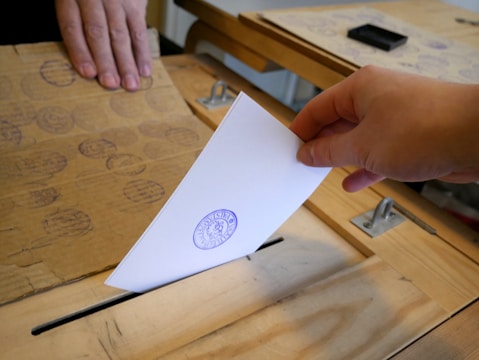 Close-up of hands casting votes in a community referendum.