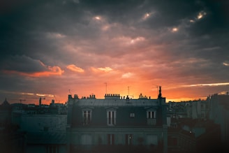 A cinematic still showing a dramatic sunset over a city skyline