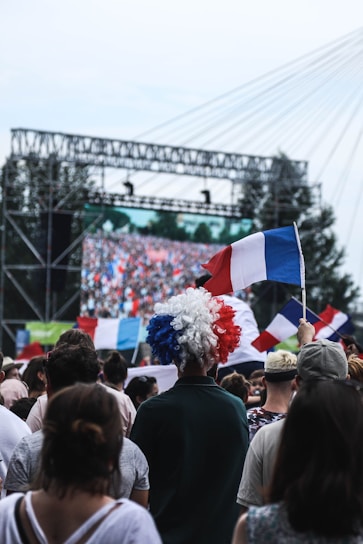 Young people united at a patriotic event with French flags and blue, white, and gold colors.