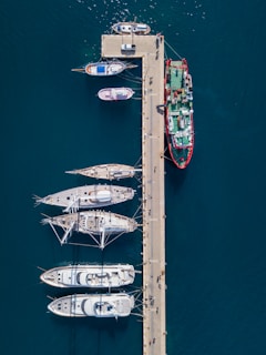 aerial photography of white and red boats near gray dock at daytime
