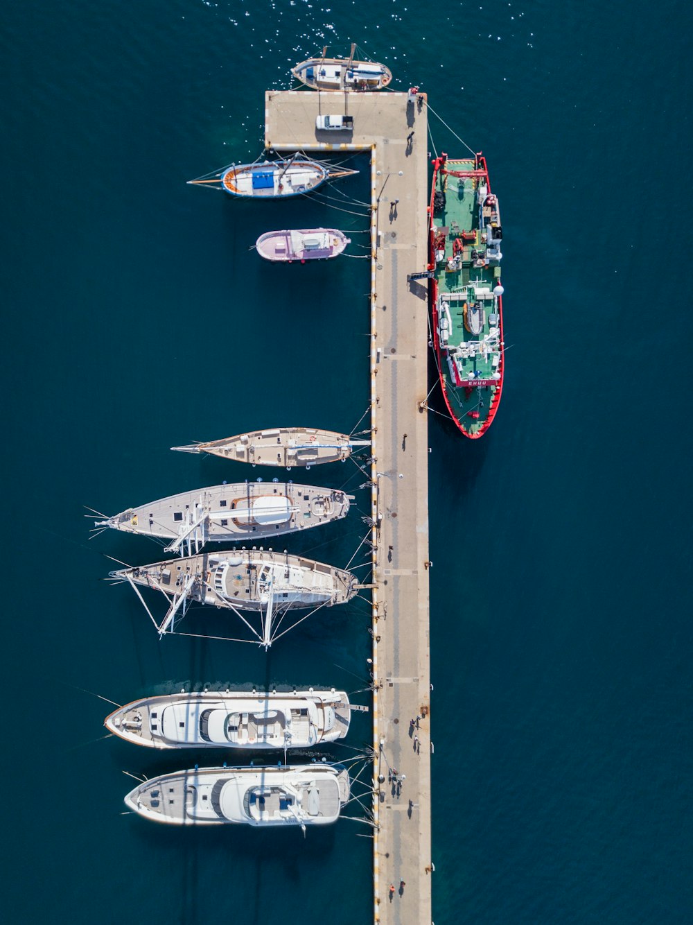 aerial photography of white and red boats near gray dock at daytime