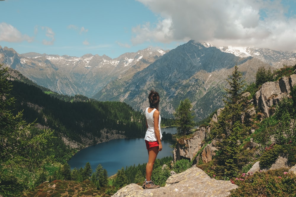 woman standing on rock on top of mountain