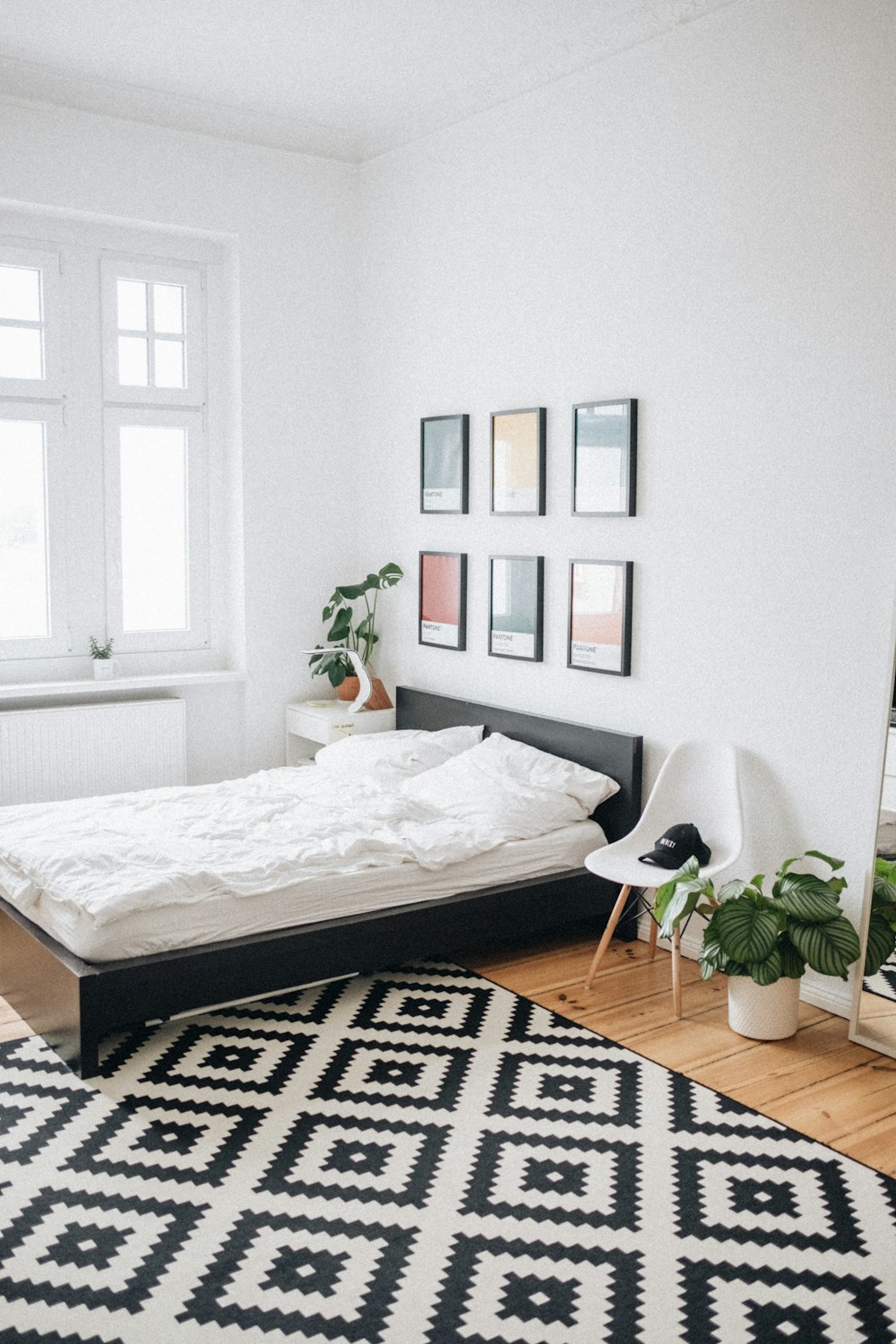 Cama de plataforma negra con colchón blanco dentro del dormitorio