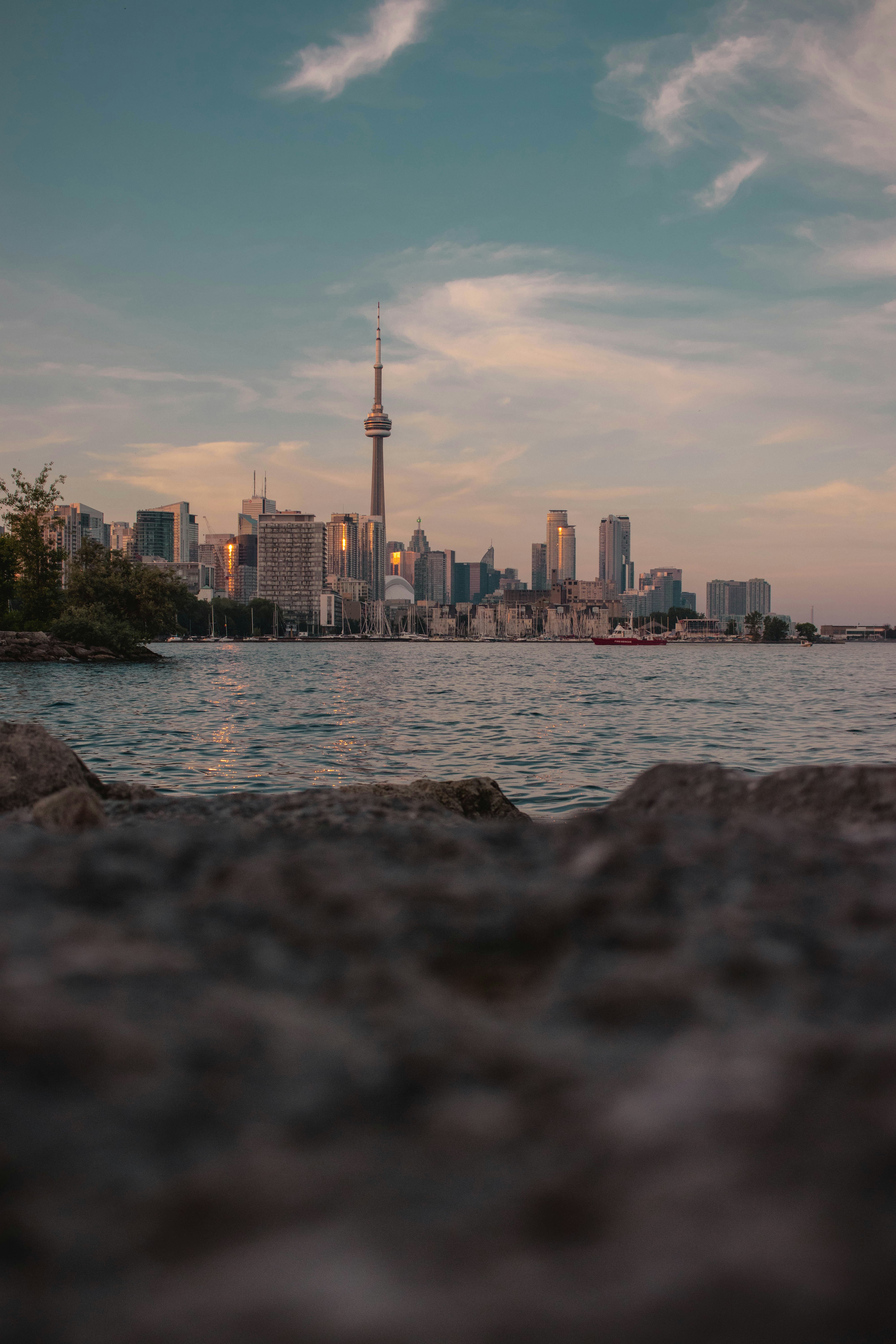 Cyclist on a lakeside path with the Toronto skyline stretching across the horizon behind them