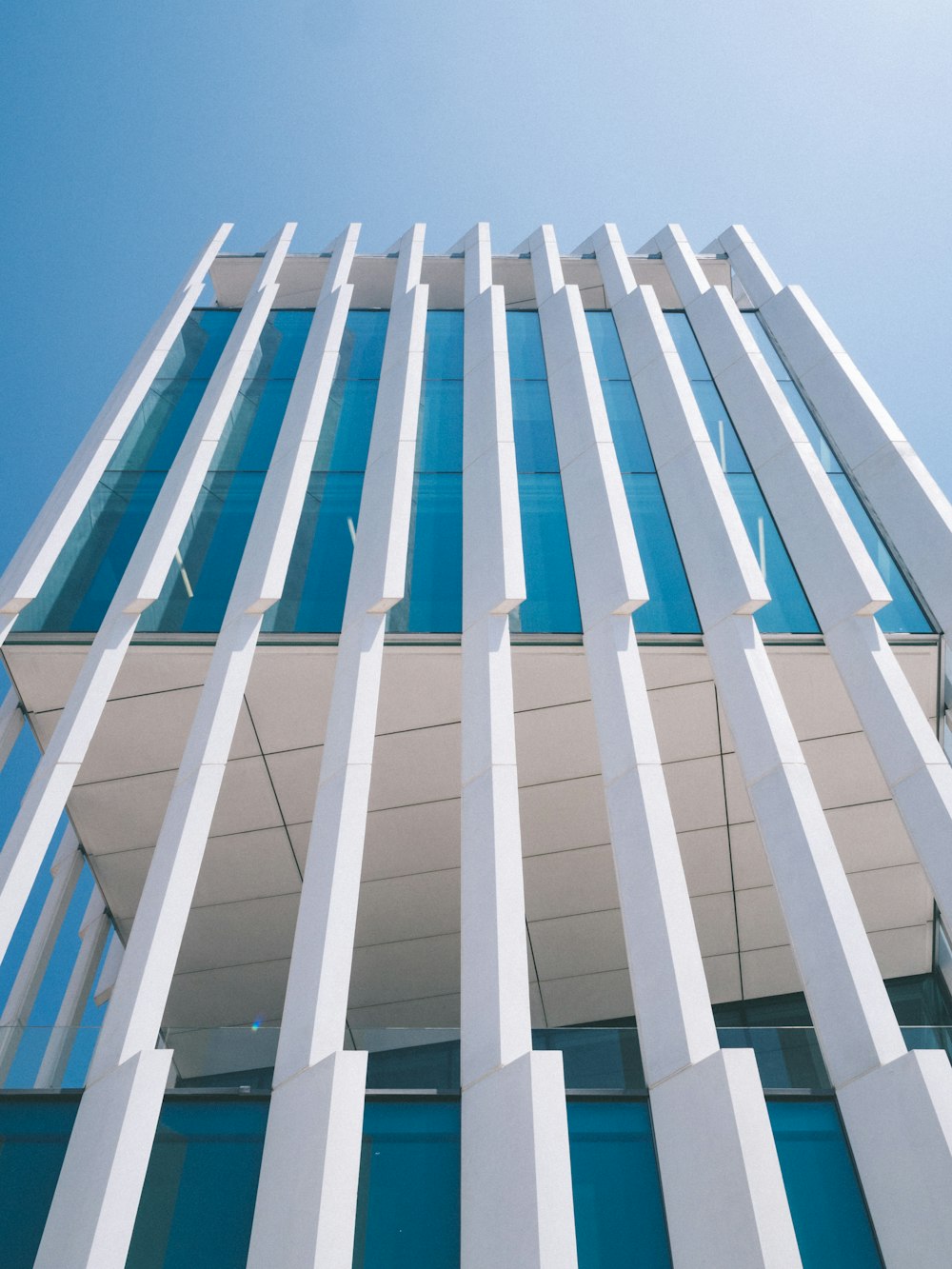 minimalist photography of white and blue high rise building