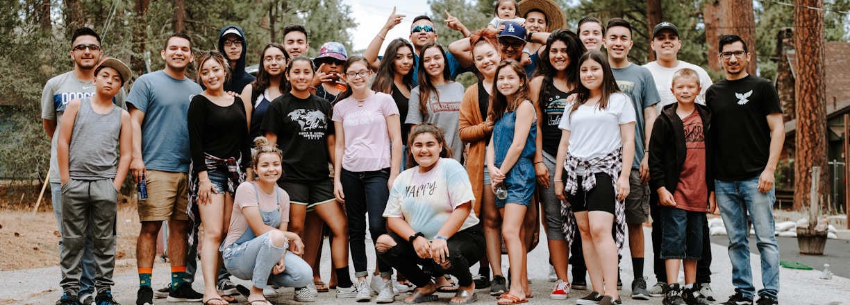 group of people taking photo near brown wooden tree