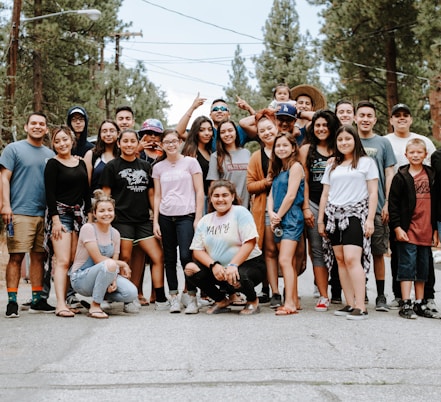 group of people taking photo near brown wooden tree