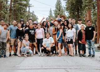 group of people taking photo near brown wooden tree