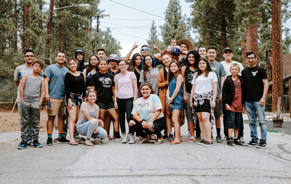 group of people taking photo near brown wooden tree