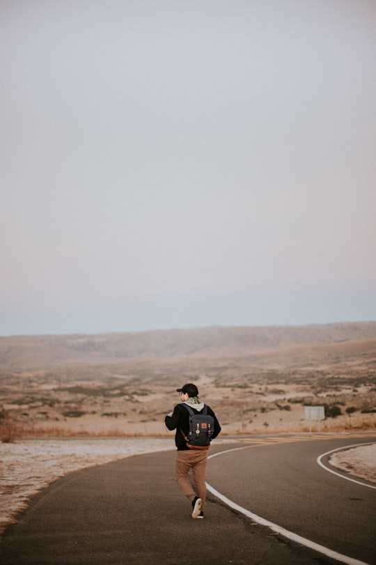 man walking in middle of asphalt road in Córdoba Argentina