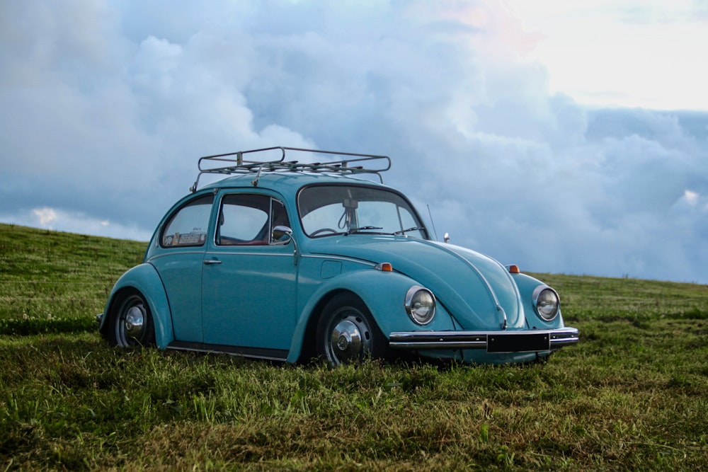 Volkswagen Coccinelle bleue sur un terrain en herbe