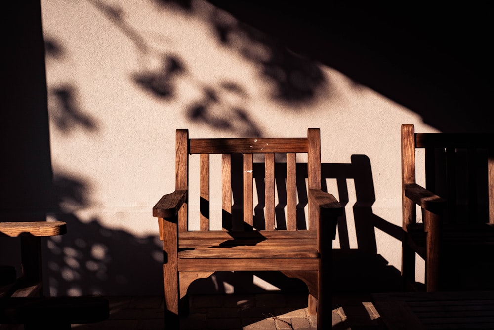 brown wooden armchairs near wall