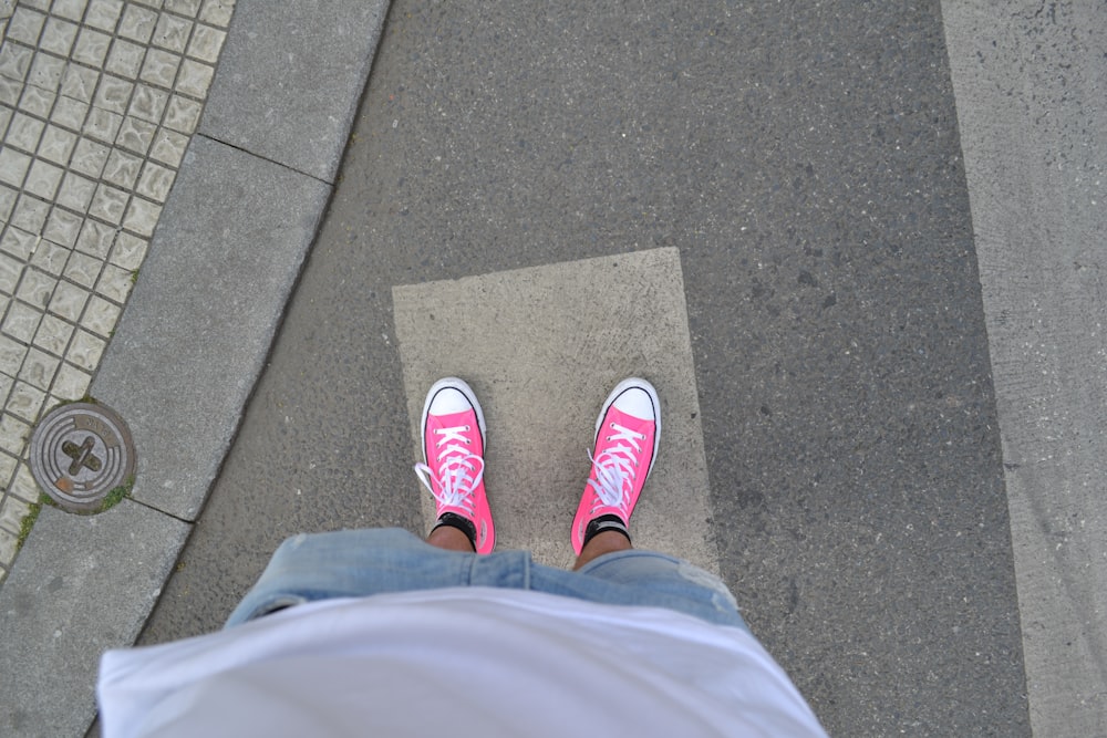 persona che indossa scarpe da ginnastica rosa