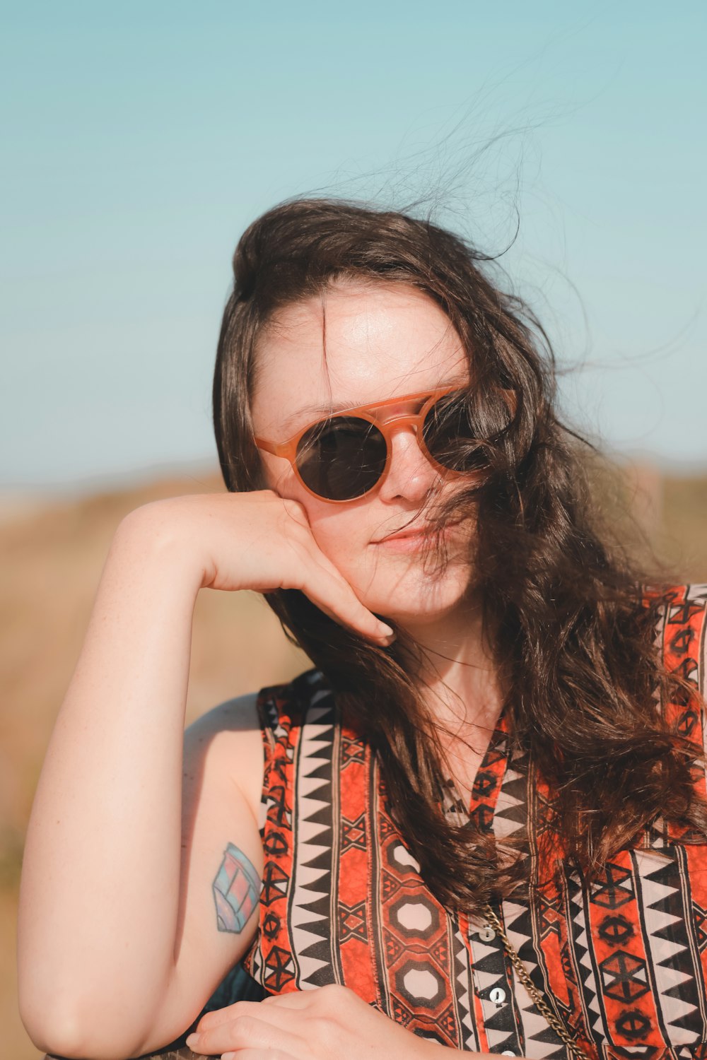 woman wearing sunglasses and orange shirt