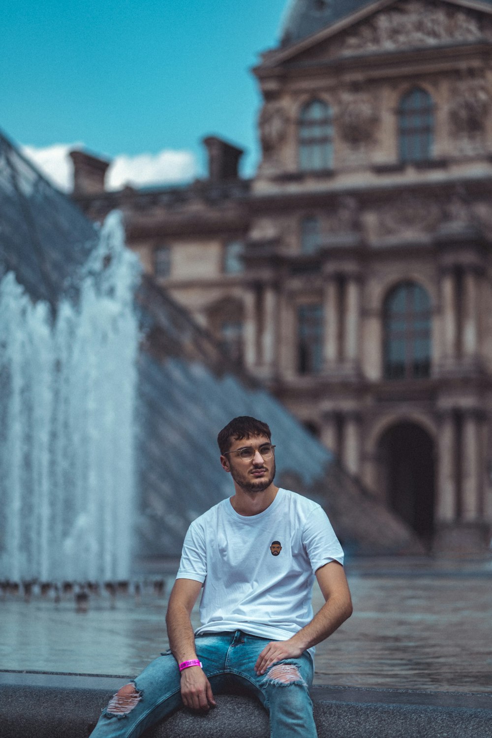 man sitting beside fountain