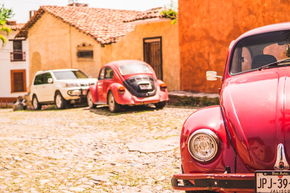 red beetle car near orange house