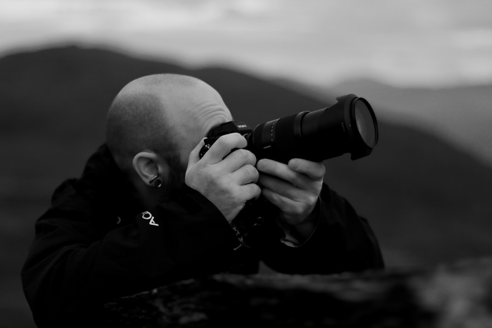 man holding black DSLR camera