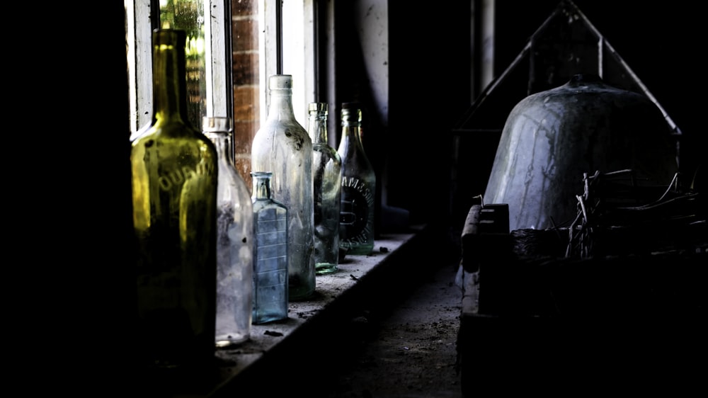 clear glass bottles on window