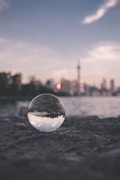 selective focus photography of glass ball on sandy ground