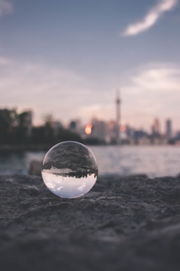 selective focus photography of glass ball on sandy ground