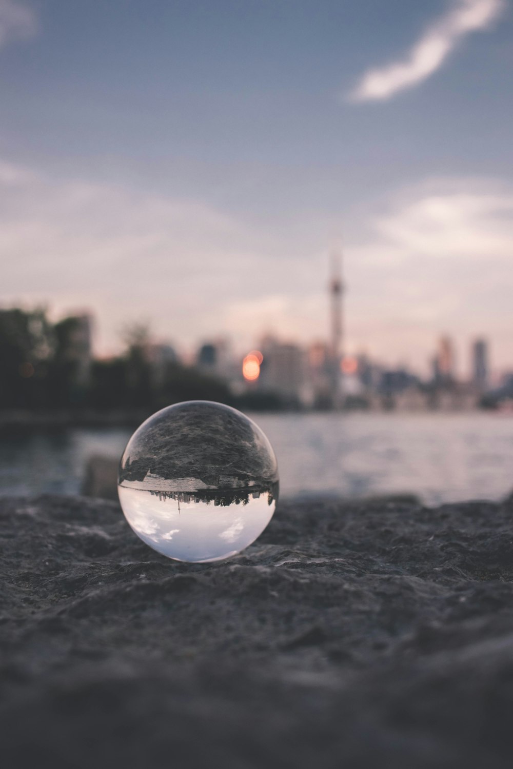 selective focus photography of glass ball on sandy ground