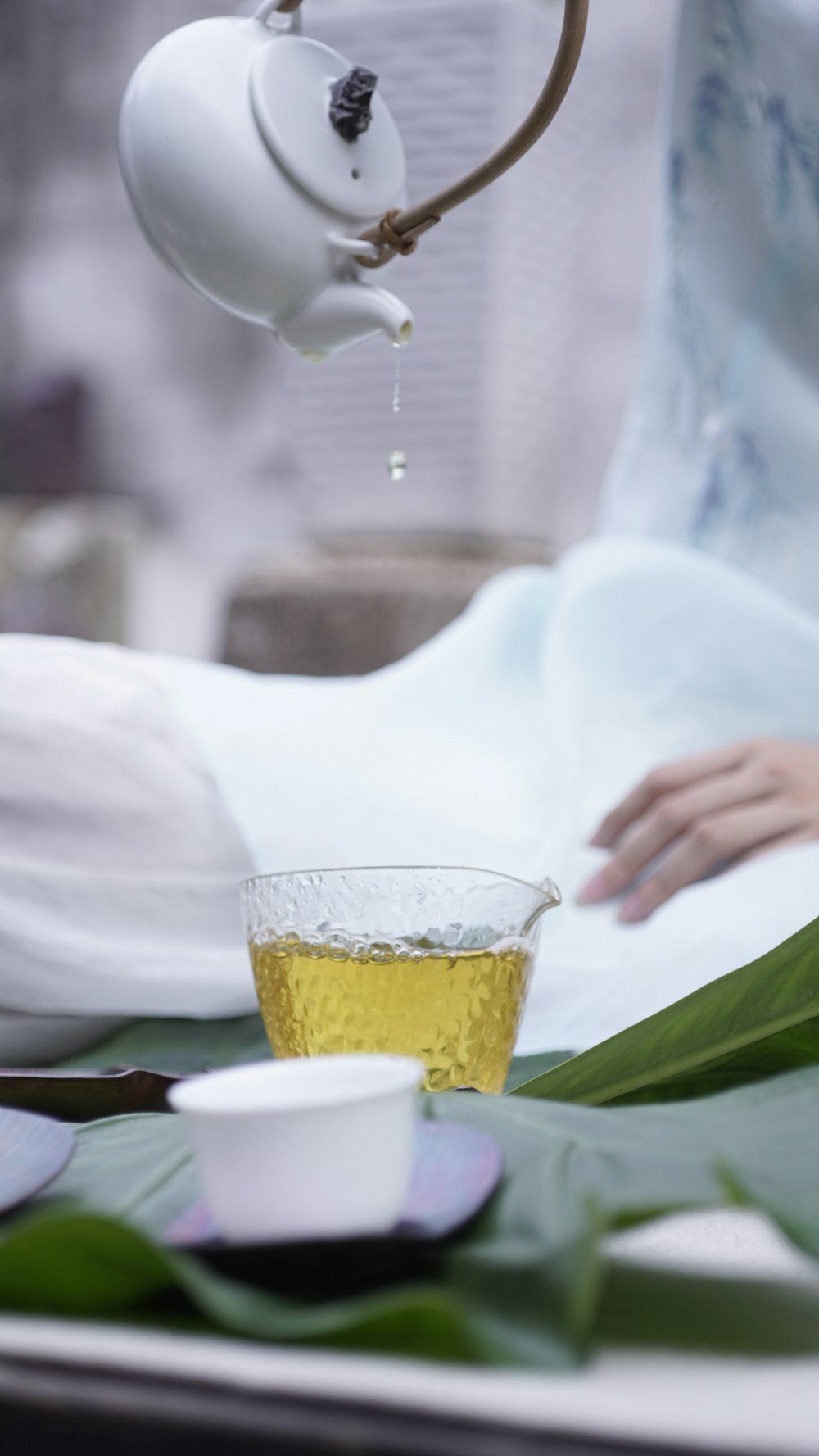 person pouring tea on glass cup