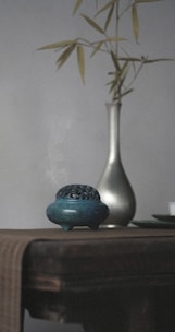 Minimalist incense burner releasing gentle smoke, set against a soft beige backdrop.