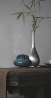 A peaceful incense burner releasing gentle smoke in a dimly lit room.