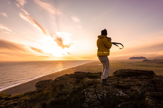 man taking sunset photo in Dyrhólaey Iceland
