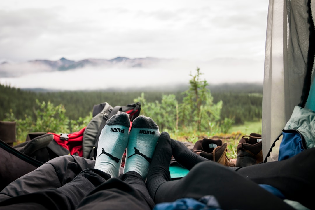 couple laying inside tent in front of mountain view