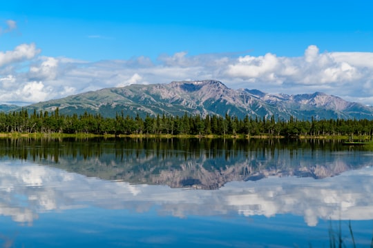 mountain and blue body of water under cloudy sky in Denali National Park and Preserve United States