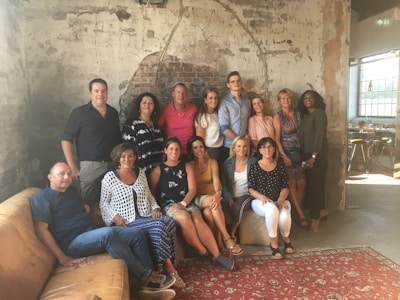 A candid photo of a small group laughing together around a cozy living room.
