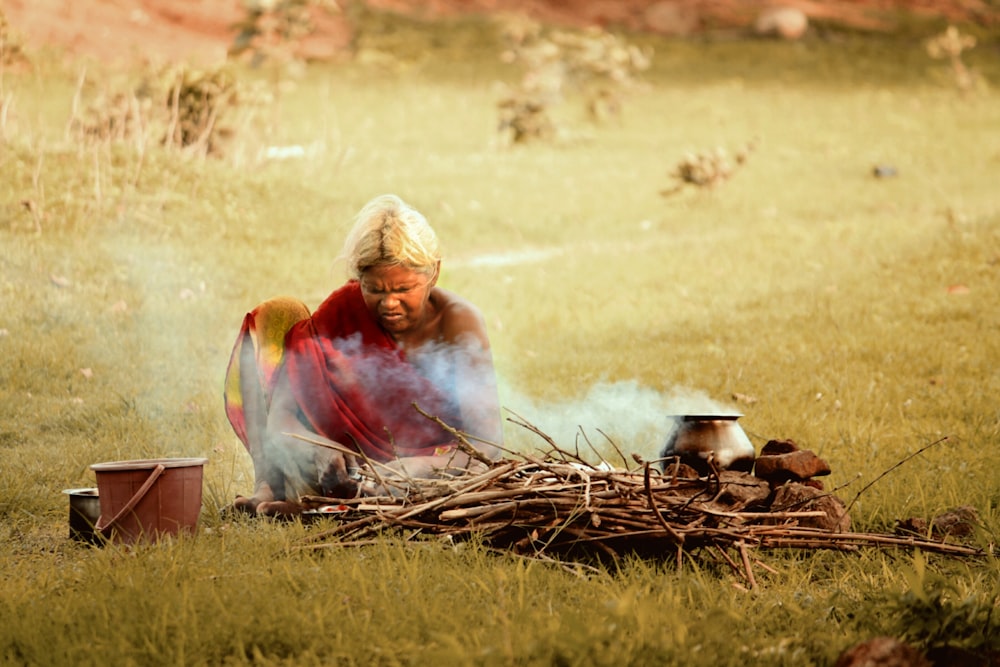 woman sitting near firewood