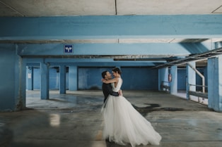 bride and groom hugging each other at parking space