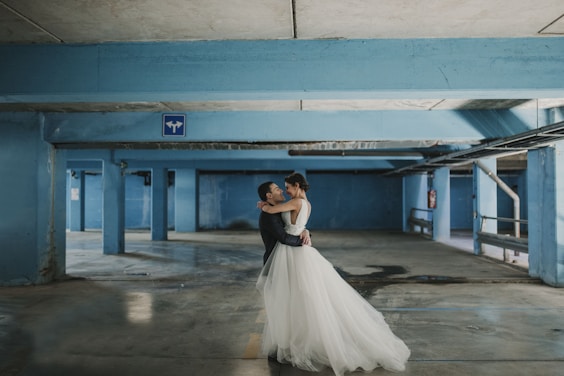 bride and groom hugging each other at parking space